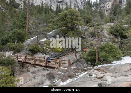 Eine hölzerne Brücke über eine felsige Schlucht in den Bergen der Sierra Nevada im Yosemite-Nationalpark, Kalifornien, USA, Nordamerika. Stockfoto