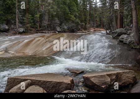 Wasser fließt über glatte Felsen im Merced River in den Sierra Nevada Mountains des Yosemite National Park, Kalifornien, USA, Nordamerika. Stockfoto