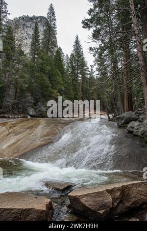 Wasser fließt über glatte Felsen im Merced River in den Sierra Nevada Mountains des Yosemite National Park, Kalifornien, USA, Nordamerika. Stockfoto
