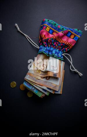 Indische Geldtüte voller Geld auf schwarzem Hintergrund. Stockfoto