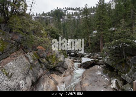 Ein Fluss fließt durch die felsige Landschaft der Sierra Nevada im Yosemite-Nationalpark, Kalifornien, USA, Nordamerika. Stockfoto