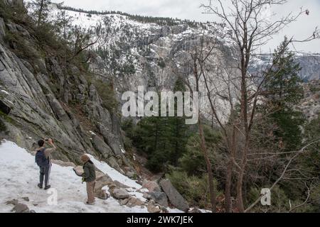 Wanderer halten an, um Fotos zu machen und den Blick auf die Sierra Nevada im Yosemite-Nationalpark, Kalifornien, USA, zu bewundern. Stockfoto