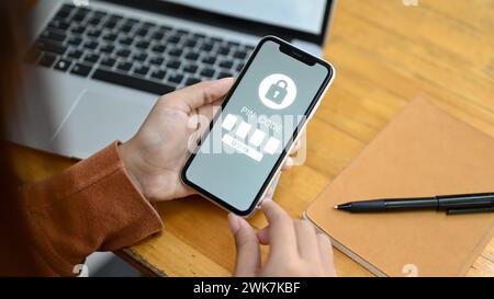 Frau Hand, die den PIN-Code auf dem Smartphone eingibt. Datensicherheitskonzept Stockfoto