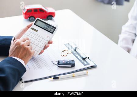 Autohändler bieten Kunden Werbeaktionen an und berechnen die Kosten für das Leasing eines neuen Elektrofahrzeugs. Käufer haben sich bereit erklärt, Elektrofahrzeuge von d Stockfoto