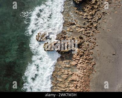 Ein Blick aus der Vogelperspektive auf den weitläufigen felsigen Strand und das Meer Stockfoto