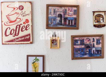 Bilder unterschiedlicher Größe an der Wand. Café-Innenraum. Café-Shop-Design. Kunstprodukte. Ich malte Bilder an die Wand. Stockfoto