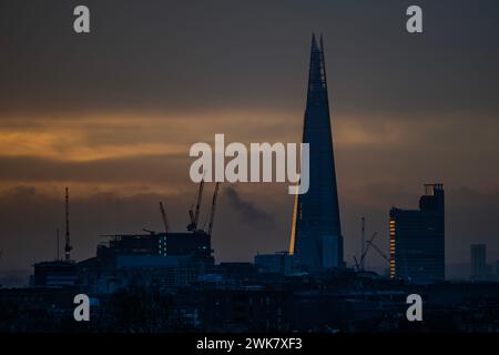 London, Großbritannien. Februar 2024. Die Sonne steigt in der Nähe des Shard auf (von Primrose Hill aus gesehen) und führt zu orangefarbenen Himmeln, bevor sie in einer niedrigen Wolkendecke verschwindet. Guy Bell/Alamy Live News Stockfoto