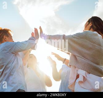 Porträt von vier fröhlichen, lachenden Frauen, die sich die Hände hochhielten und High Five beim Wandern im Freien machten. Sie starren in die Kamera. Frauenfreundschaft, Nat Stockfoto