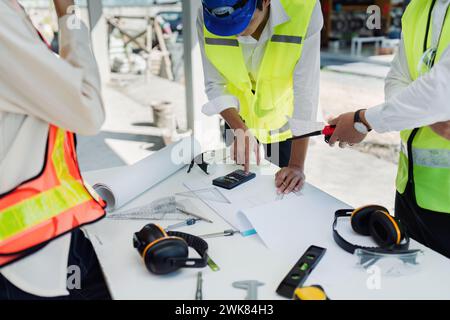 Teamingenieur, Vorarbeiter und Architekt treffen sich für Kollegen, die Baupläne vor Ort besprechen und prüfen Stockfoto