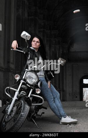 Porträt einer Frau in einer Lederjacke auf einem Vintage-Motorrad Stockfoto