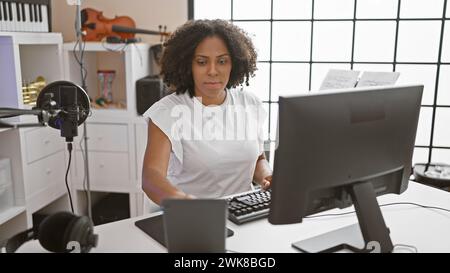 afroamerikanerin, die Musik in einem Heimstudio produziert Stockfoto