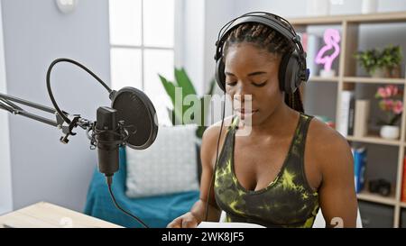 Eine afroamerikanische Frau mit Zöpfen sendet in einem Radiostudio Stockfoto