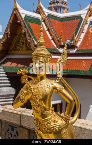 Goldene Statue eines mythischen Thepnorasi bewacht den Tempel des Smaragdbuddhas im Grand Palace Complex in Bangkok, Thailand. Stockfoto