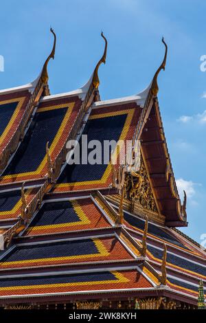 Dachdetail des Tempels des Smaragdbuddhas im Grand Palace Complex in Bangkok, Thailand. Die ausgeklügelte Chofa, bai raka und hong Hongse sind s Stockfoto
