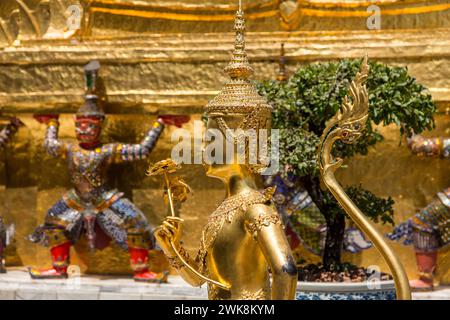 Goldene Statue eines mythischen Thepnorasi bewacht den Tempel des Smaragdbuddhas im Grand Palace Complex in Bangkok, Thailand. Stockfoto