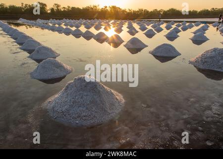 Salzhaufen schaffen geometrische Designs auf der Salzpfanne einer traditionellen Salzfarm in Samut Sakhon, Thailand. Stockfoto