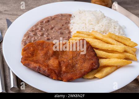 Mailänder Rindfleisch, Reis, Bohnen und pommes frites. Typisch brasilianisches Gericht. Stockfoto