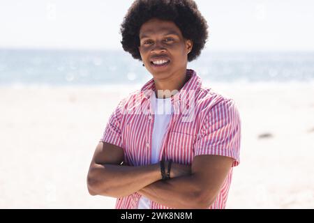 Ein junger Afroamerikaner lächelt am Strand Stockfoto