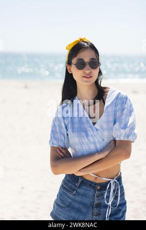 Eine junge, birassische Frau steht selbstbewusst am Strand Stockfoto