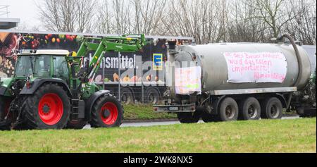 Lauenau, Deutschland. Februar 2024. Traktoren blockieren eine Zufahrtsstraße zu einem Lager des Einzelhandelsunternehmens Edeka in der Nähe der Autobahn A2 im Stadtteil Schaumburg. Der Zugang zum und vom Standort sei nicht möglich, sagte eine Sprecherin der Polizeiwache Nienburg/Schaumburg. Fast 40 Fahrzeuge nahmen an der Blockade Teil. Quelle: Julian Stratenschulte/dpa/Alamy Live News Stockfoto