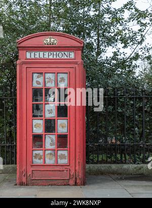 London, Großbritannien - 15. Februar 2024 - traditionelle rote Telefonkabine in London City. Klassische rote britische Telefonbox, Platz für Text, selektiver Fokus. Stockfoto