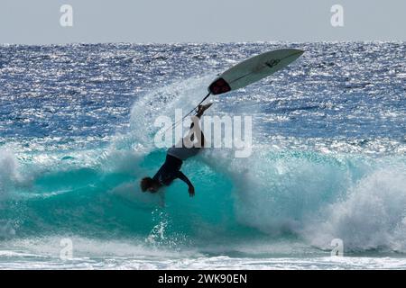 Ein männlicher Surfer, teilweise unter Wasser, hat Einen spektakulären Fall beim Surfen im Atlantik, Drill Hall Beach, Bridgetown, Christ Church, Barbados Stockfoto