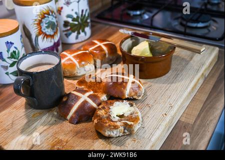 Getoastete Hot Cross Brötchen mit Butter ein traditionelles Frühstück, das zu Ostern gegessen wird Stockfoto