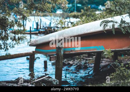 Das Boot wurde an einem bewölkten Tag am Ufer eines Flusses abgestellt. Stockfoto