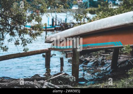 Das Boot wurde an einem bewölkten Tag am Ufer eines Flusses abgestellt. Stockfoto