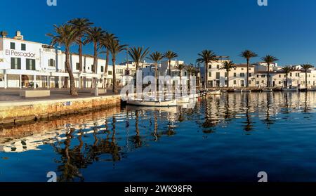 Fornells, Spanien - 25. Januar 2024: Blick auf das Dorf und den Hafen von Fornells im Norden Menorcas mit Reflexionen im Wasser Stockfoto