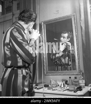 Morgenrasierung 1949. Actor Curt Masrelief rasiert sich mit einem Elektrorasierer. Beachten Sie, dass sich die Zigarette in ihrem Mund befindet, während Sie sich rasieren. 1949. Kristoffersson Ref. AN26-2 *** Lokale Bildunterschrift *** © Classic Picture Library. Alle Rechte vorbehalten. Geschützt durch eine digitale Signatur. Bildüberwachung und -Schutz ist auf diesem Bild aktiviert. Die Lizenz, Präsentation oder Newsletter beinhaltet KEINE Nutzung in sozialen Medien. Stockfoto