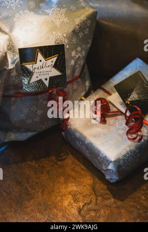 Zwei weihnachtsgeschenke in silbernem Papier unter einem weihnachtsbaum. Stockfoto