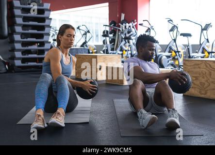 Ein vielseitiges Paar, das im Fitnessstudio trainieren und sich auf die gemeinsame Stärkung der Rumpfmuskulatur konzentrieren kann Stockfoto