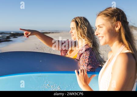Zwei junge kaukasische Frauen genießen einen sonnigen Strandtag mit Kopierraum Stockfoto