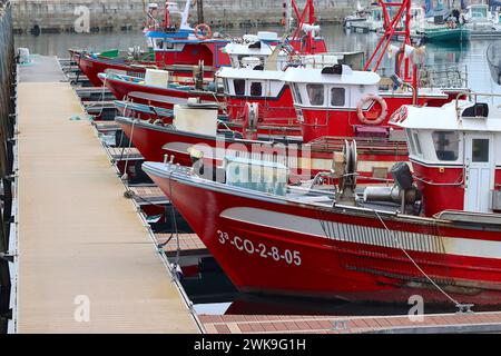 Farbenfrohe Flotte von Fischerbooten, die im April 2023 in den geschützten Gewässern von Port El Ferrol, La Coruna, Galicien, Spanien vor Anker gebracht wurden. Stockfoto