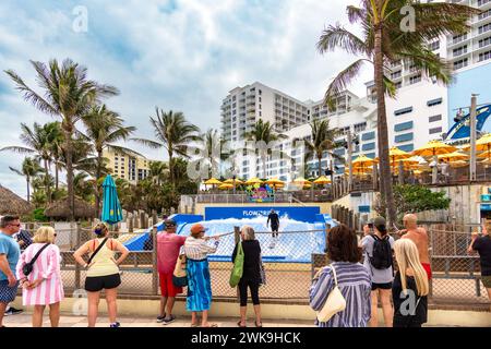 Hollywood Beach, FL - USA - 9. Februar 2024 Zuschauer treffen sich, um die akrobatischen Meisterleistungen eines Surfers zu beobachten, während er durch die Wellen auf der Palmenlinie schneidet Stockfoto