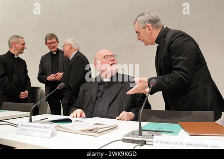 Die katholische Bischoefe in Augsburg berät vom 19.02.2024 an bei Ihrer Fruehjahrsvollversammlung ueber kirchenpolitische und gesellschaftliche Fragen. Im Foto vom 19.02.2024: Nuntius Nikola Eteroviczum r spricht mit Kardinal Reinhard Marx vor Beginn der Vollversammlung der Deutschen Bischofskonferenz im Haus Sankt Ulrich auf dem Podium, 2.l. Rainer Maria Kardinal Woelki, Kardinal der römisch-katholischen Kirche und seit 2014 Erzbischof von Köln. Im Mittelpunkt der Vollversammlung steht das Wahljahr 2024 mit seinen Landtagswahlen im Osten und der Zustand der Demokratie, wie die katholisc Stockfoto