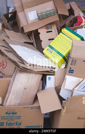 Entsorgte Kartonschachteln auf dem Bürgersteig der Stadt, die zum Recycling abgeholt werden können. Stockfoto