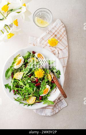 Löwenzahnsalat mit Eiern, Kartoffeln und Bohnen auf hellen Tischhintergrund Stockfoto