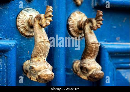 Nahaufnahme von verzierten Türklopfern an einer alten blauen Tür in Lissabon, Portugal Stockfoto