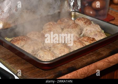 Saftige und heiße Koteletts aus Schweinefleisch im Ofen liegen auf einem Backblech. Stockfoto