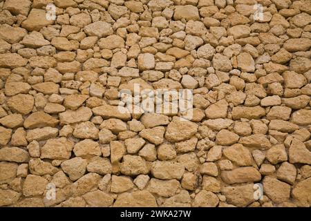 Nahaufnahme von braunen Korallenfelsen in der Stützmauer, Albufeira, Algarve, Portugal. Stockfoto