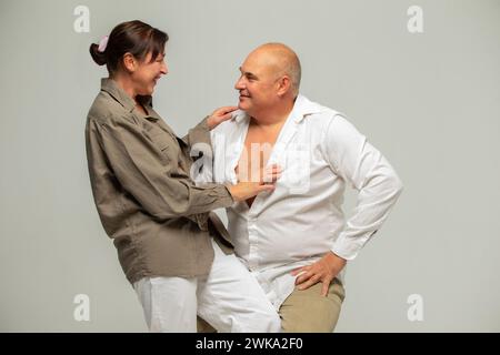 Porträt eines älteren Paares. Fröhliches lachendes lustiges Paar, zwei Freunde, älterer grauhaariger brünette Mann in lässiger Kleidung stehend, umarmt und com Stockfoto