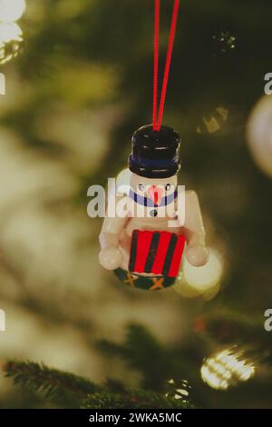 Nachts hängt ein Schneemannsschmuck an einem Weihnachtsbaum Stockfoto