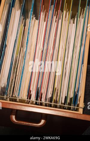 Nahaufnahme von bunten Ordnern im Aktenfach aus Holz. Stockfoto