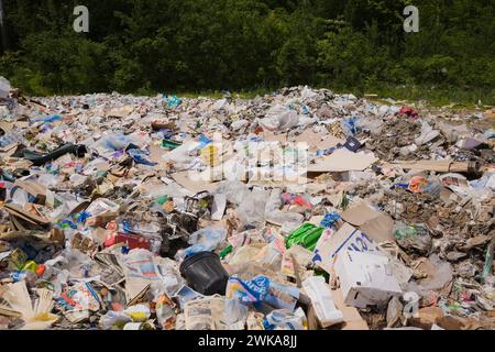 Stapel verschiedener recycelbarer Kunststoff- und Papiermaterialien im Sortierzentrum. Stockfoto