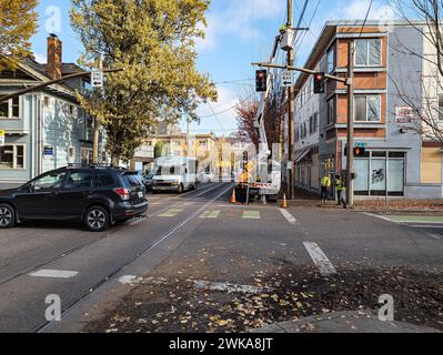 Portland, Oregon, USA - 11.08.2023: Kommunale Arbeiter reparieren Stromübertragungsleitungen. Mobiles Auto in einem Korb auf einer Stadtstraße. Stockfoto