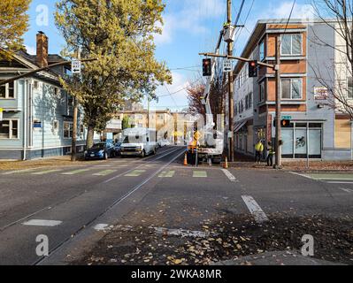 Portland, Oregon, USA - 11.08.2023: Kommunale Arbeiter reparieren Stromübertragungsleitungen. Mobiles Auto in einem Korb auf einer Stadtstraße. Stockfoto