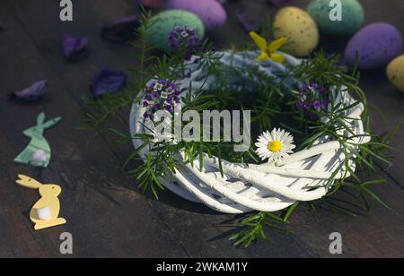 Holzkranz mit Blumen und bunten ostereiern Stockfoto