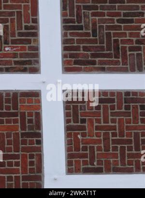 Detailansicht einer Mauer aus einem ländlichen Fachwerkhaus in der Altstadt bei Hamburg, eed-Ziegelsteine, weiße Fugen und Holzbalken, schönes Beispiel Stockfoto